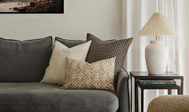 a couch with pillows and a lamp