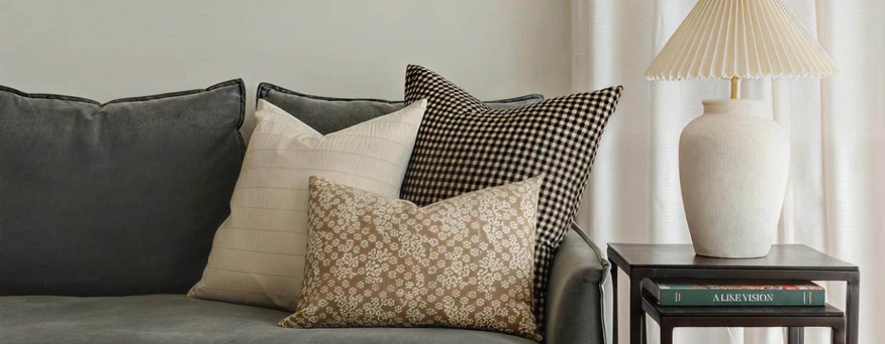 a couch with pillows and a lamp