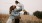 a man and woman holding their child in a field